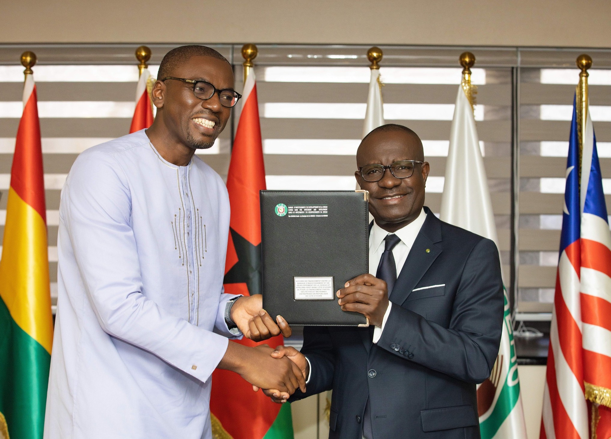 Exchange of signed documents between George Agyekum Donkor, President of EBID, and Christian Kammogne Fogaing, Managing Director of Afriland First Bank Côte d’Ivoire.