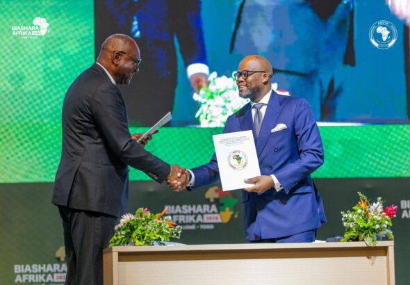 Handshake between Mory Diané, founder of Scanning Systems (left), and the Executive Secretary of the AfCFTA, Wamkele Mene, during the signing of the Memorandum of Understanding.